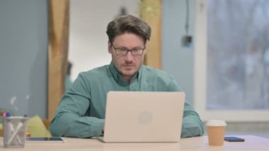 Mature Adult Businessman having Back Pain while using Laptop