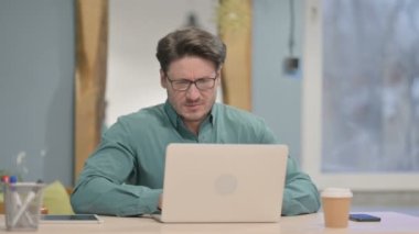 Mature Adult Businessman having Neck Pain while using Laptop