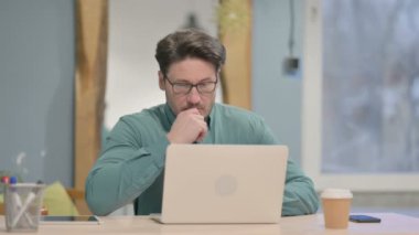 Mature Adult Businessman Thinking while Working on Laptop