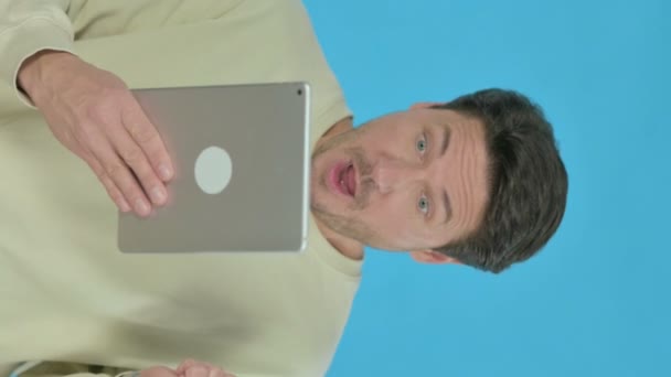 Handsome Young Man Celebrating Success Tablet Blue Background Vertical Video — Vídeo de stock