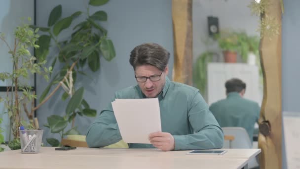 Middle Aged Businessman Feeling Upset Reading Documents Paperwork — Video