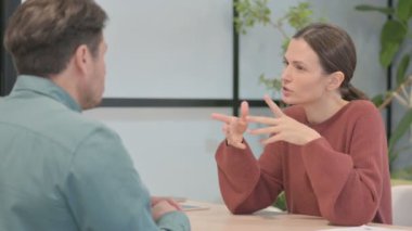 Young Woman Talking to Male Partner in Office