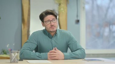 Pensive Mature Adult Businessman Thinking while Sitting in Office