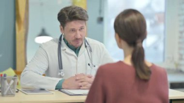 Klinikte erkek doktor hastasıyla konuşuyor.