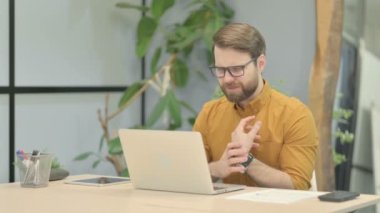 Orta yaşlı iş adamı dizüstü bilgisayar kullanırken bilek ağrısı çekiyor