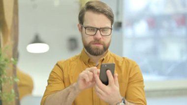 Middle Aged Businessman using Smartphone for Browsing Internet