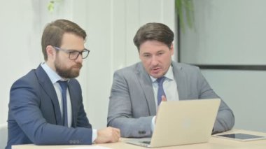 Confident Businessmen Discussing Online Business Report on Laptop