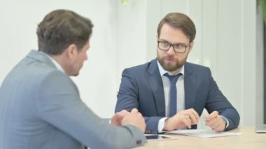 Businessman Discussing Project with Partner in Office
