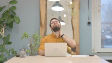 Middle Aged Businessman having Neck Pain while using Laptop