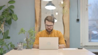 Middle Aged Businessman Coughing while Working on Laptop