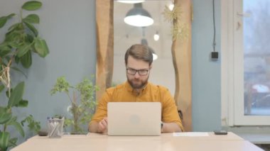 Middle Aged Businessman Celebrating Online Success on Laptop at Work