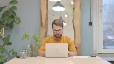 Middle Aged Businessman Reacting to Loss While Working at Work