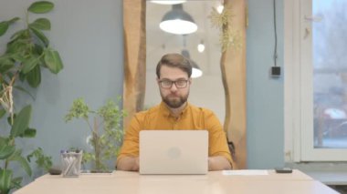 Middle Aged Businessman Shaking Head in Rejection while Working on Laptop