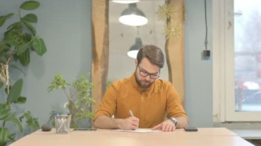 Middle Aged Businessman Reading Documents at Work, Paperwork