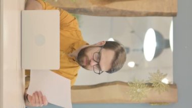 Middle Aged Businessman Working on Laptop and Documents, Vertical Video