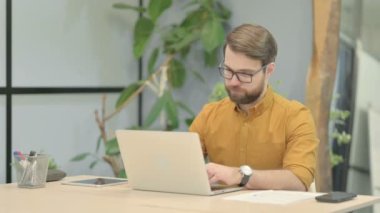 Middle Aged Businessman Leaving Office after Closing Laptop