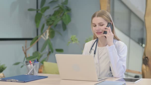 Young Doctor Talking Phone While Using Laptop — Stock Video