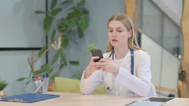 年轻的医生浏览智能手机在诊所 — 图库视频影像