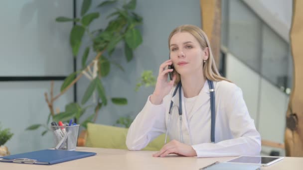 Fiatal Doktor Beszél Telefonon Klinikán — Stock videók