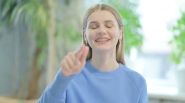 Portrait of Casual Young Woman Pointing at the Camera