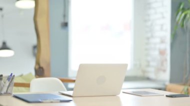 Young Woman Coming to Work, Typing on Laptop