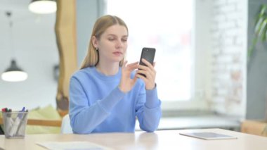 Successful Young Woman Celebrating Win on Smartphone