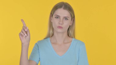 Rejecting Casual Young Woman in Denial on Yellow Background