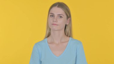 Casual Young Woman Shaking Head in Denial on Yellow Background