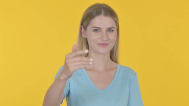 Casual Young Woman Inviting on Yellow Background