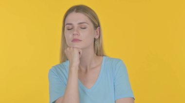 Casual Young Woman Sleeping on Yellow Background