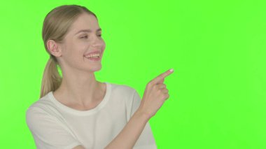 Casual Young Woman Pointing on Side on White Background