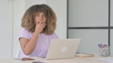 Ofiste dizüstü bilgisayar kullanırken Afrikalı Amerikalı Kadın Kameraya Bakıyor