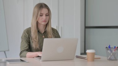 Ofiste Dizüstü bilgisayar kullanan Sarışın Genç Kadın