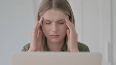 Başağrısı olan Sarışın Genç Kadının Yakın Çekimi Bilgisayarda çalışıyor