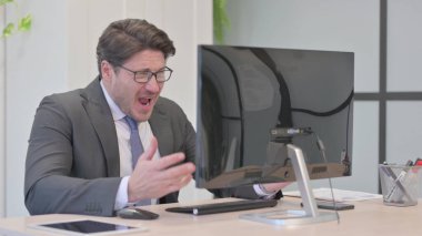 Bilgisayar üzerinde çalışırken Genç İşadamı Kayıp 'a Tepki Veriyor