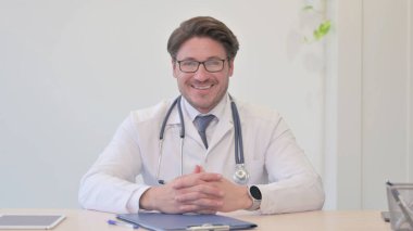 Orta yaşlı doktor kameraya gülümsüyor