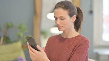 Young Woman using Smartphone for Browsing Internet