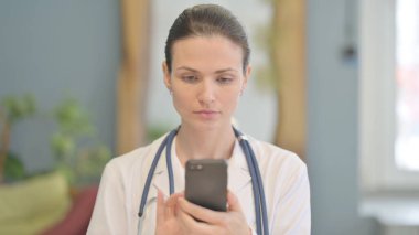 Genç bayan doktor interneti taramak için akıllı telefon kullanıyor