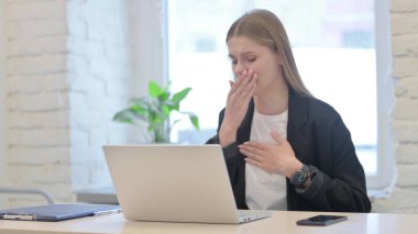 İş kadını laptopta çalışırken öksürüyor
