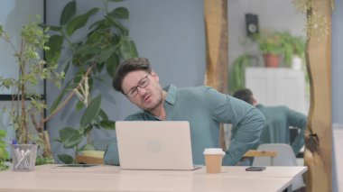 Middle Aged Businessman having Back Pain while using Laptop