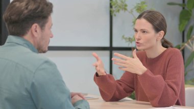 Young Woman Talking to Male Partner in Office
