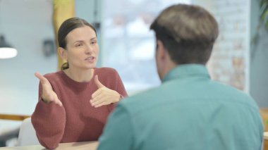 Creative Young Woman Talking to Teammate