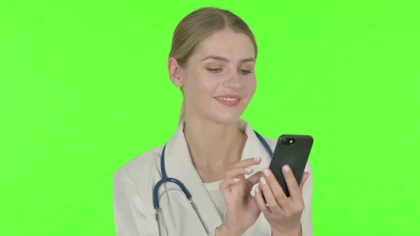 Young Female Doctor Browsing Smartphone Green Background — Stockfoto
