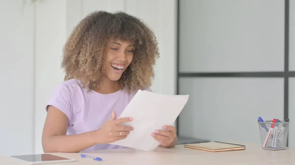 African American Woman Celebrating Win While Reading Documents