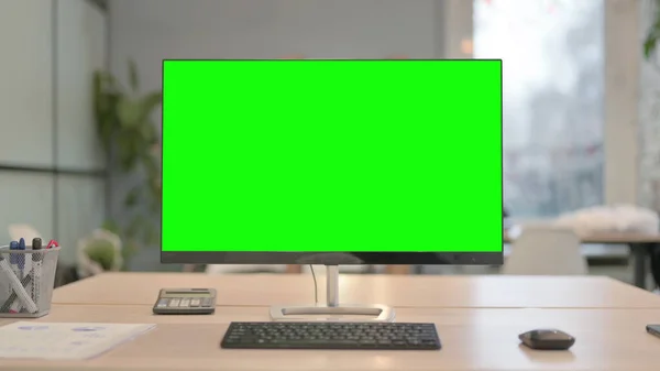 Desktop Computer with Green Screen on Desk in Office