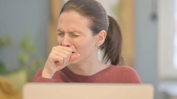 Close Up of Young Woman Coughing while Working on Laptop