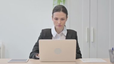 Young Businesswoman Typing on Laptop in Office