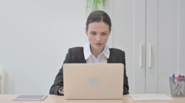 Young Businesswoman Celebrating Online Success on Laptop in Office