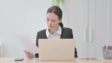 Young Businesswoman Working on Laptop and Documents