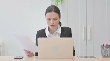 Young Businesswoman Celebrating Success while Doing Paperwork
